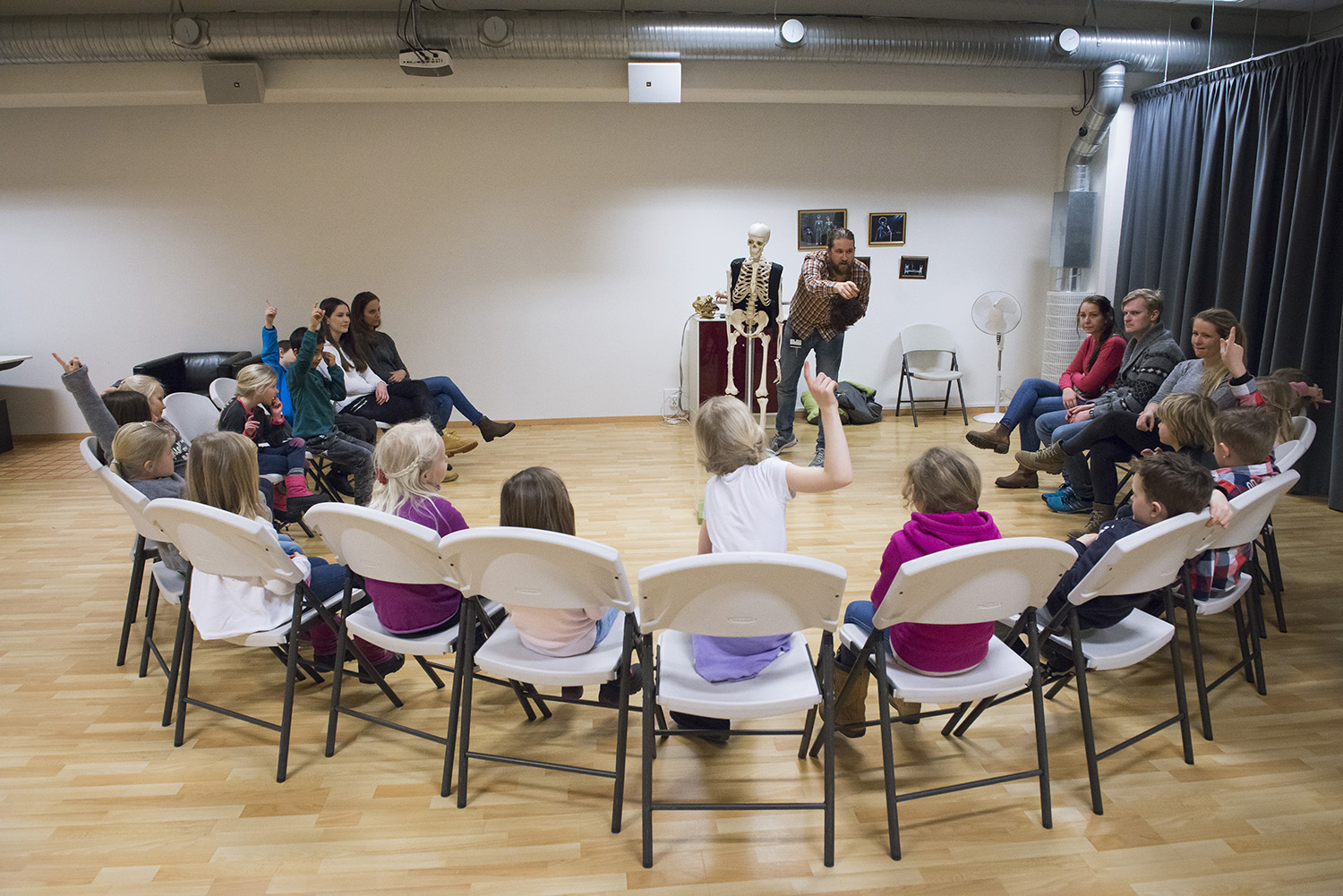 Skoleklasse som sitter i en ring med en museumspedagog