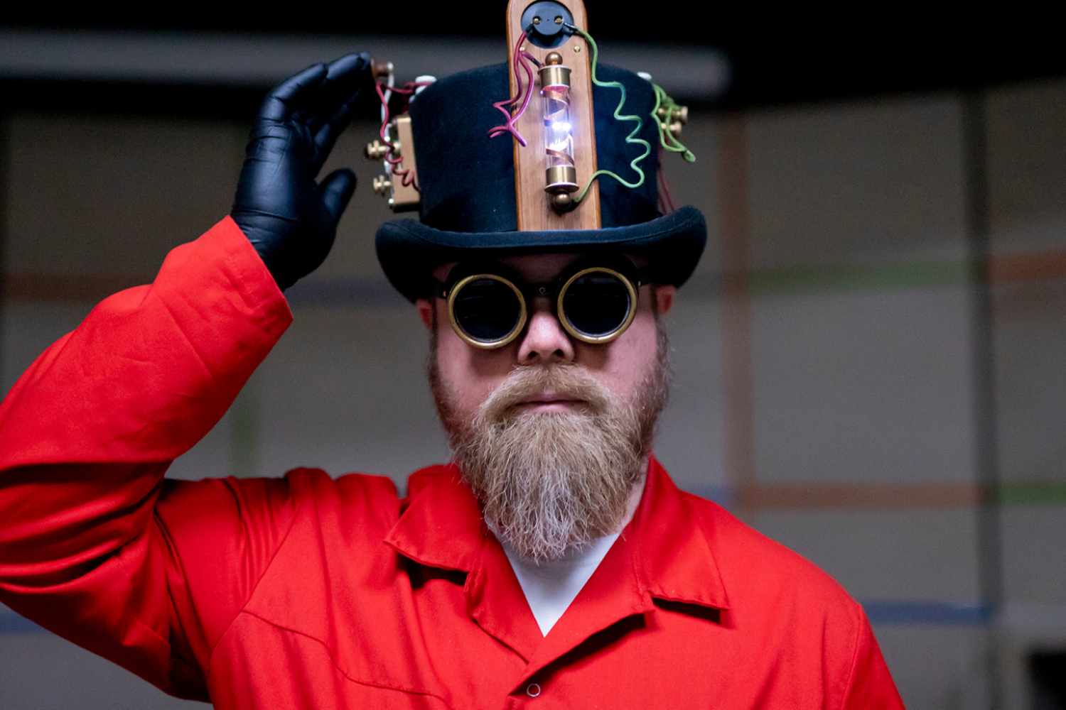 museumspedagog i rød frakk og svart flosshatt