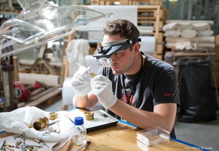 Personer flytter en kongelig bil på gårdsplassen