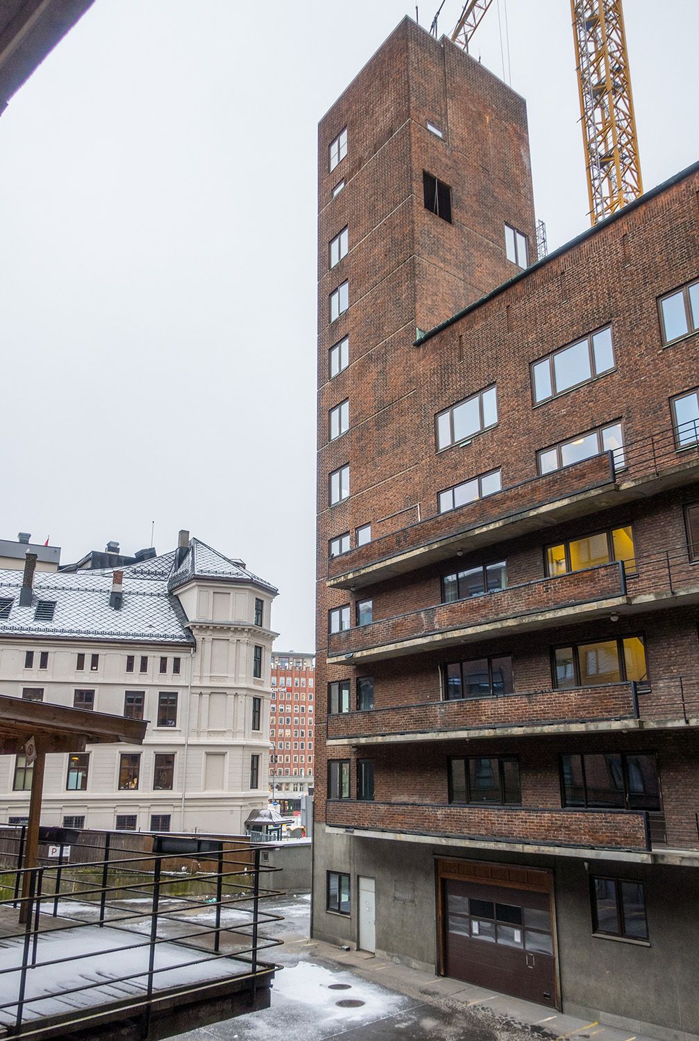 Bakgården til Oslo hovedbrannstasjon, sett fra nordfløyen mot sørfløyen og slangetørkings- og øvingstårnet. I bakgrunnen skimtes Folkets Hus på Youngstorget.