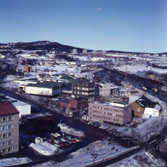 Et bylandskap med blokkleiligheter og fabrikker på vinteren